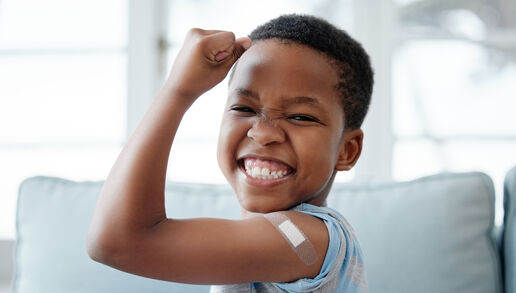 Portrait of a little boy with a bandage on his arm after an injection