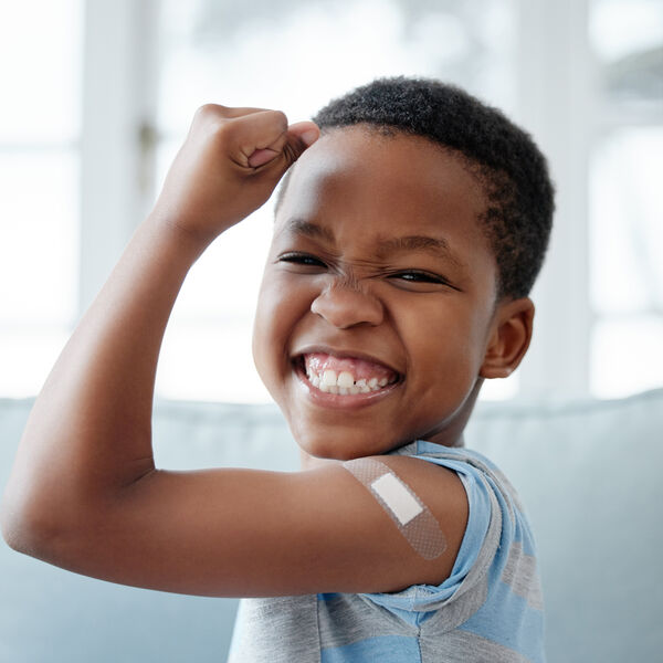 Portrait of a little boy with a bandage on his arm after an injection