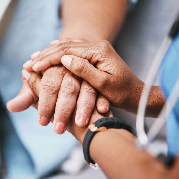Health care provider holding a patient's hand